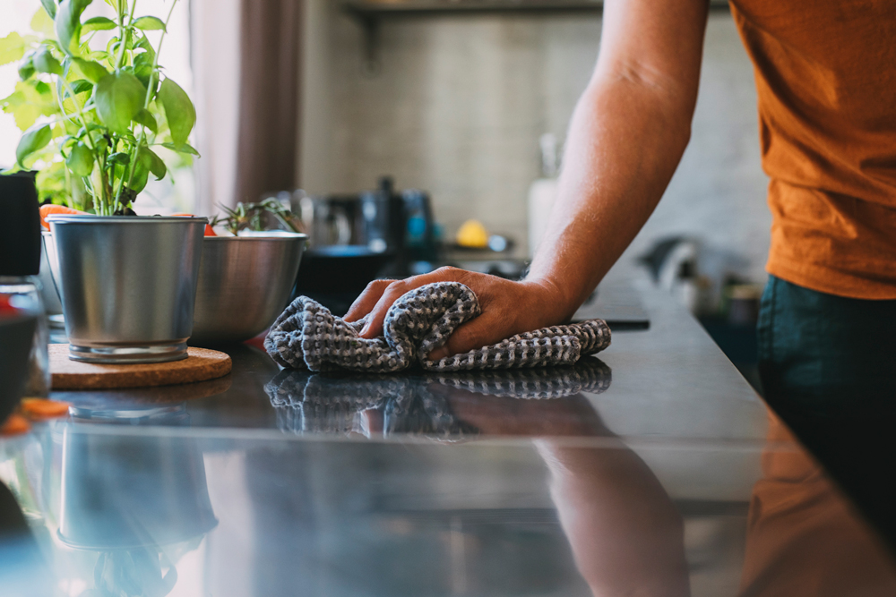 Man cleaning counter with towel