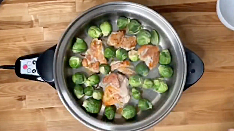 Fry and sautee pan with fried chicken and brussel sprouts