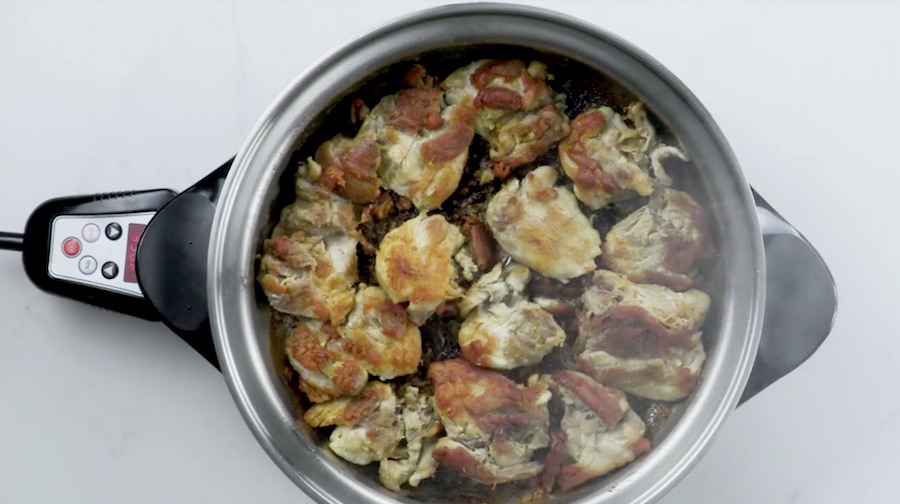 showing chicken cooking  in Saladmaster Electric Oil Core Skillet with cover